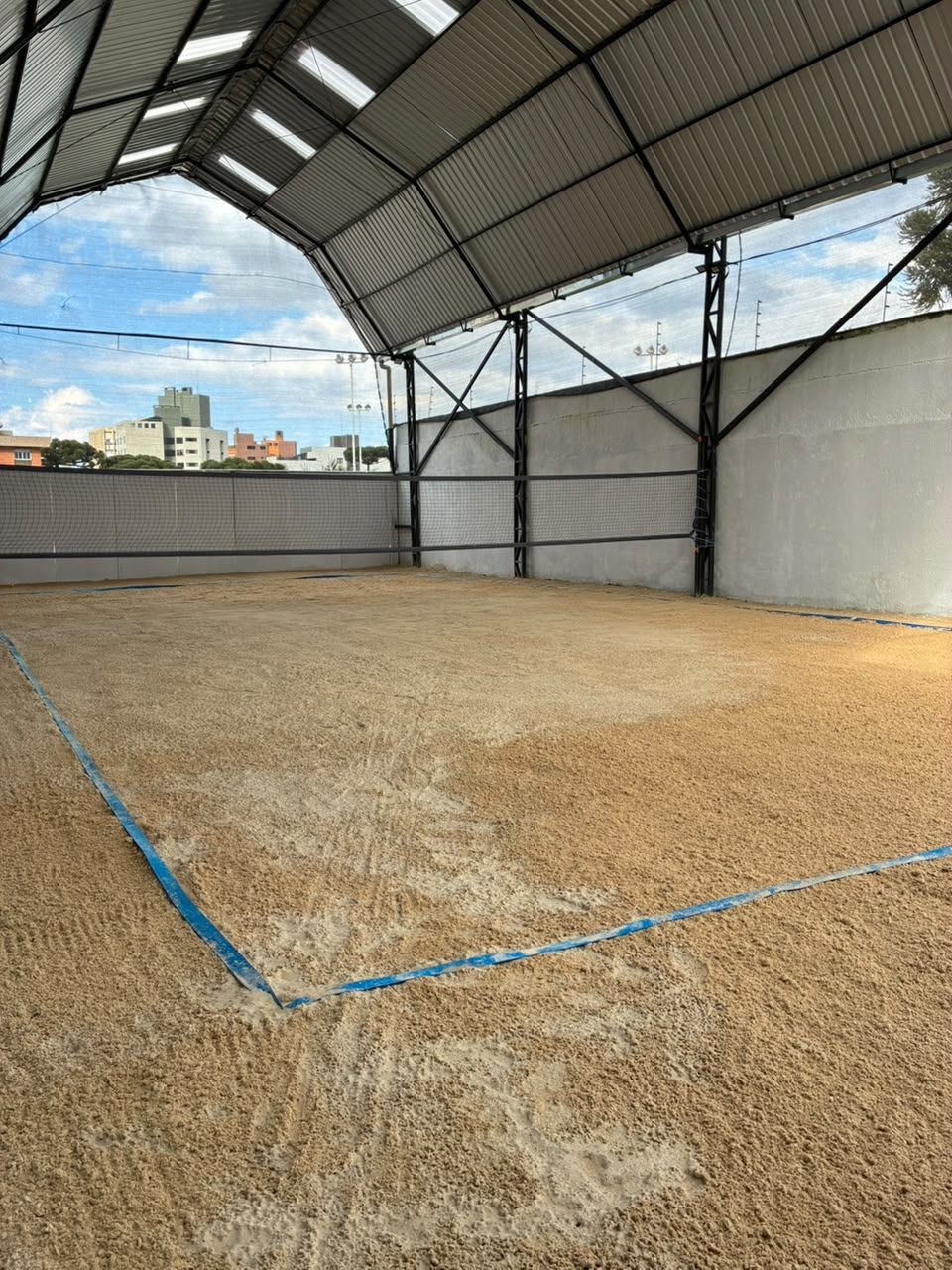 Quadra coberta de beach tênis do ZF Arena, com areia